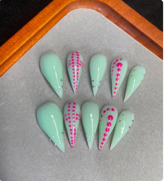 Mint green stiletto press-on nails with pink dot design